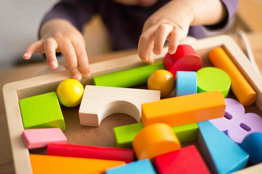 Child playing with colourful toys in a nursery setting