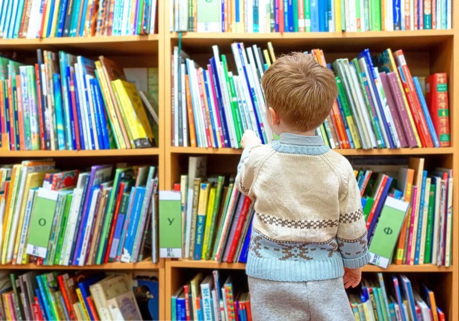 Early years child exploring books in a community library setting