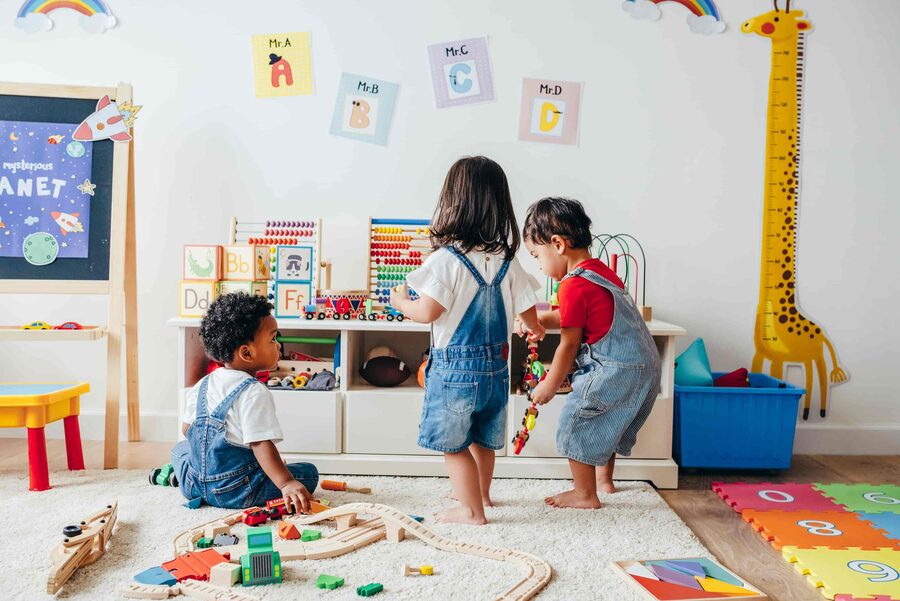 Group of nursery children enjoying time in a colourful indoor playroom