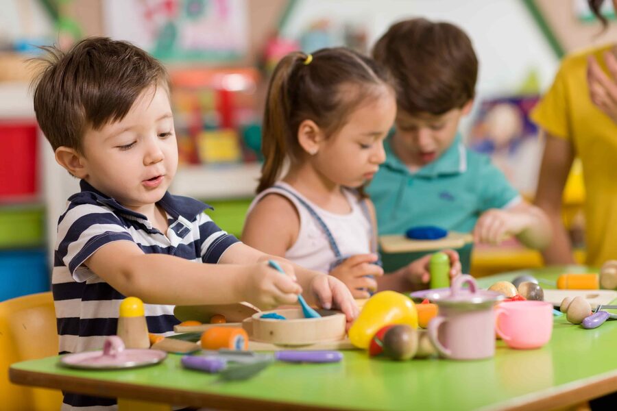 Young children sculpting with clay in a nursery classroom