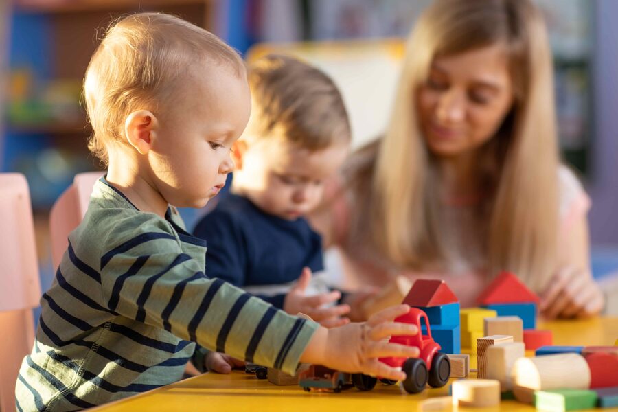 Kindergarten teacher and children playing in an early years environment